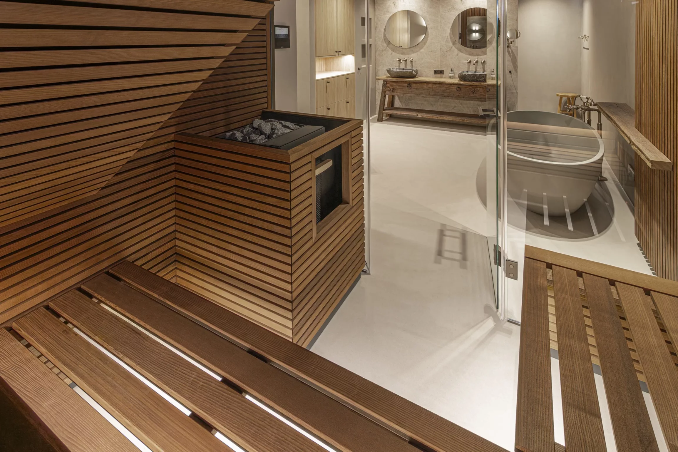 Grote badkamer met glazen wanden naar sauna, ovaal vrijstaand bad, houten lattenwanden