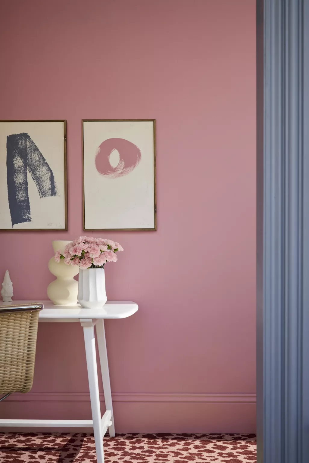 Roze wand met schilderijen