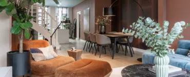 Interieur woonkamer met bruine chaises longue en donkerbruin behang