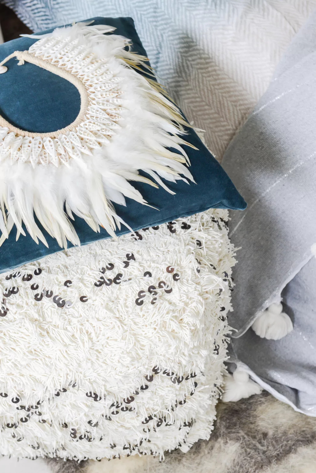 Detail van kussens en sprei in een slaapkamer met blauwtinten.