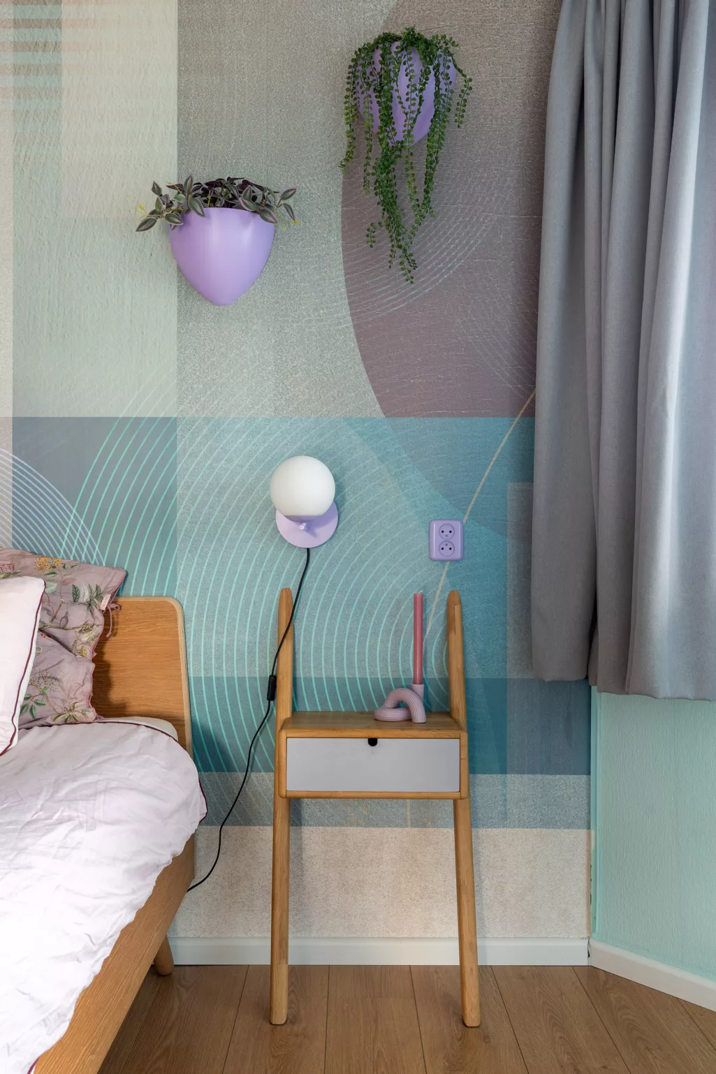 Slaapkamer met grafisch behang in verschillende tinten blauw en donkerpaars. 