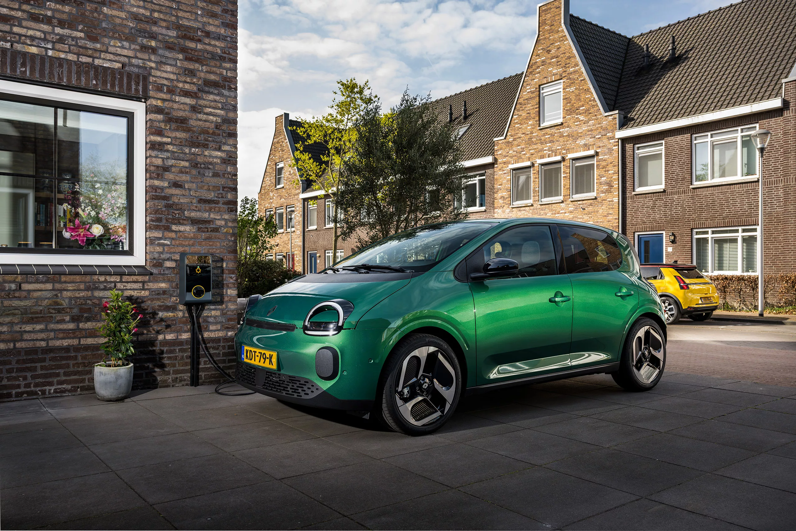 Elektrische auto aan laadpaal op oprit 