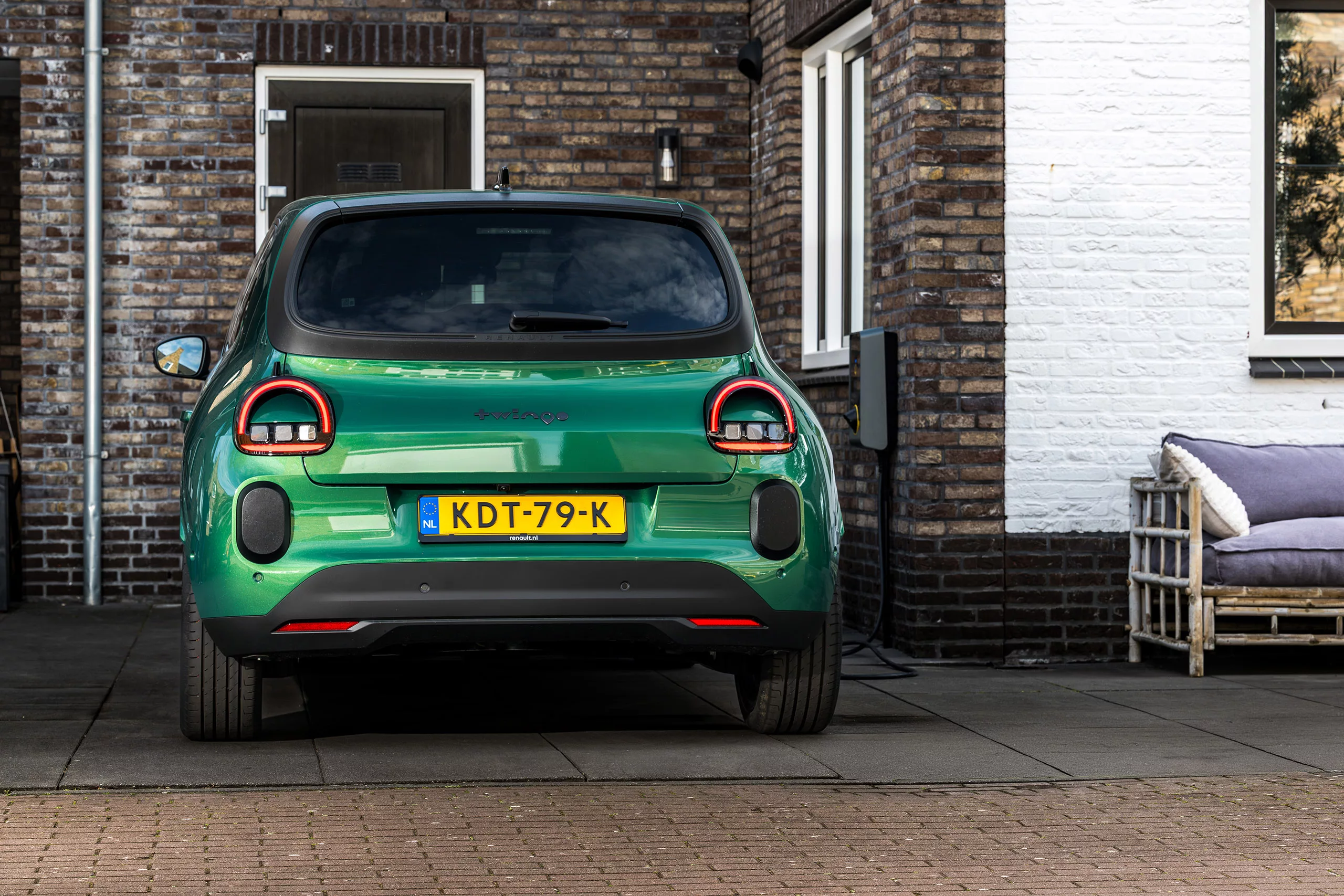 Elektrische auto aan laadpaal op kleine oprit bij nieuwbouwwoning