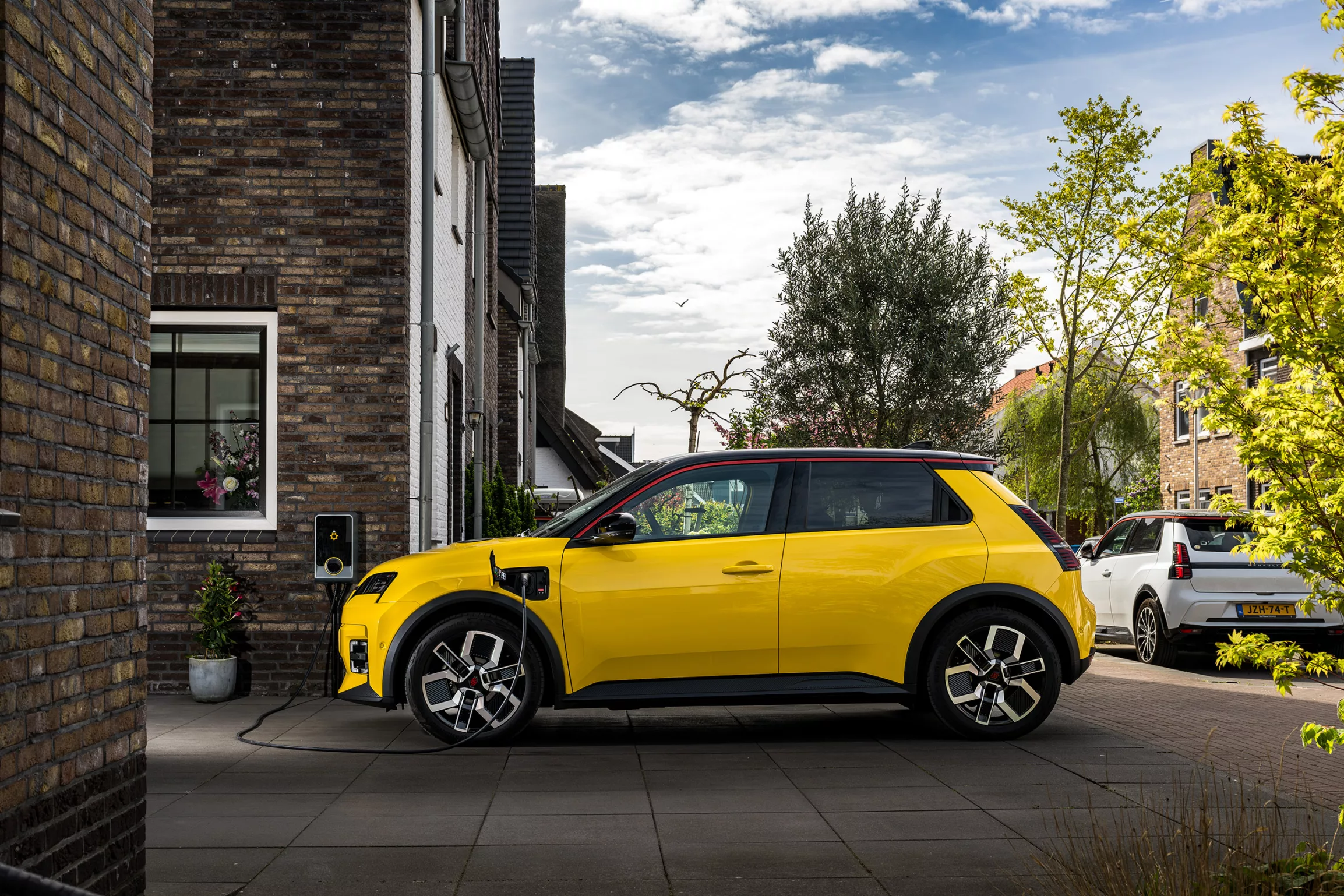 Renault 5 op oprit, nieuwbouw woning met kleine baksteentjes