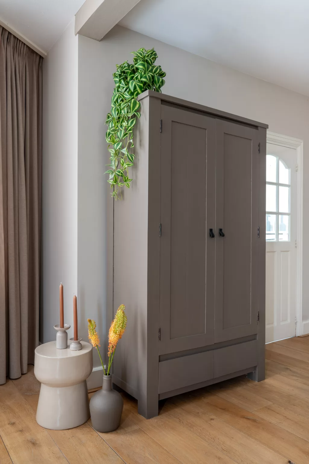 Klassieke woonkamer, houten vloer, grote kast in kleur Rolling Fog dark, stenen ronde bijzettafel, rolling fog light wanden