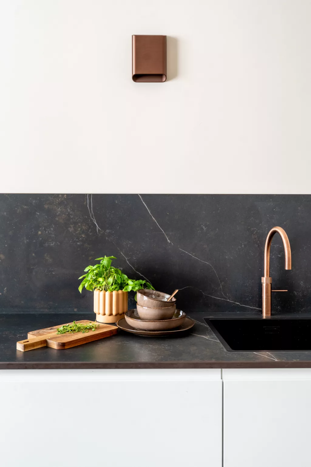 Detail Kelya werkblad met diverse bruine accessoires, koperkleurige quooker