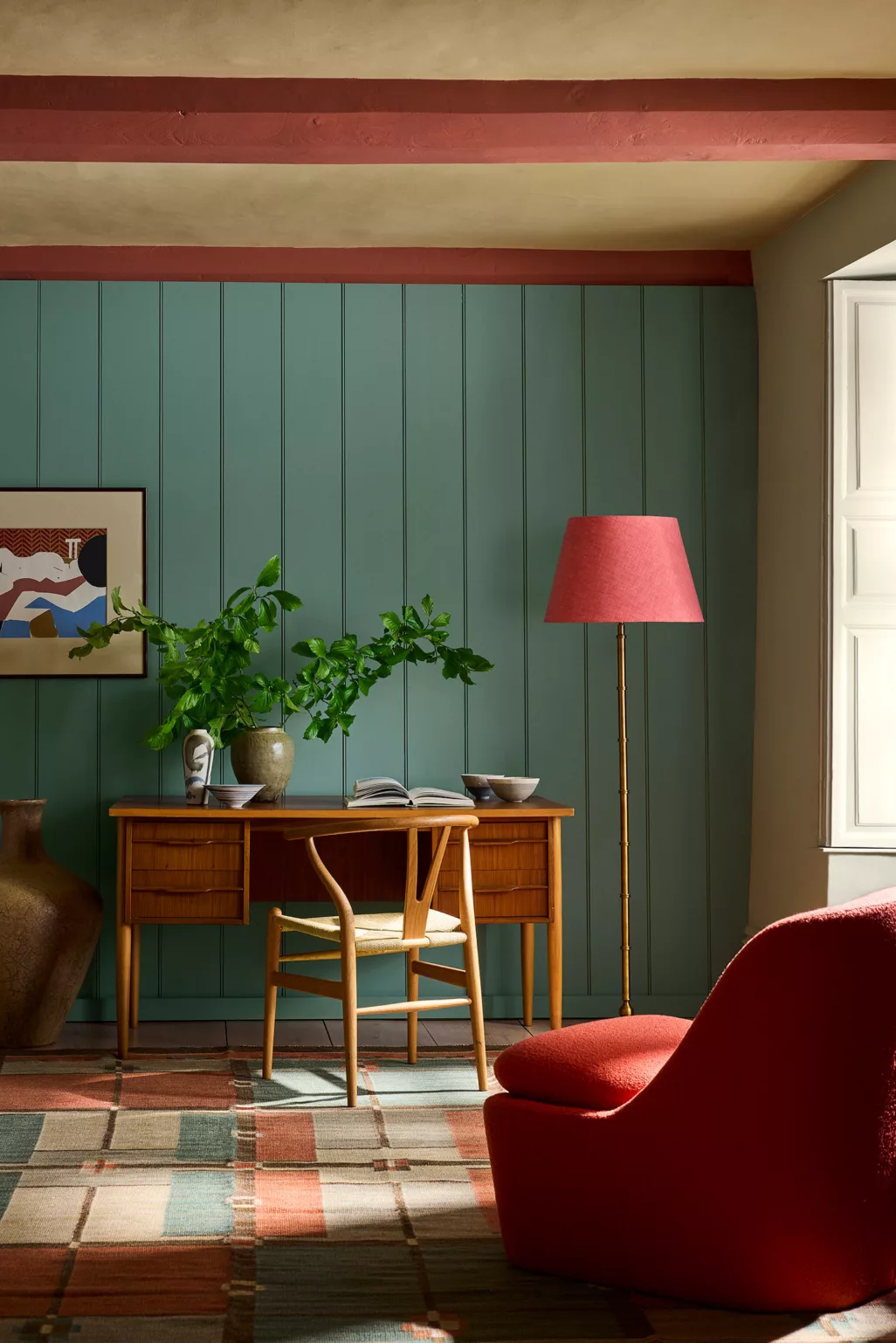 Perpetual blue op houten lattenwand, donker roze stoelen en lampenkap, rotan bureau